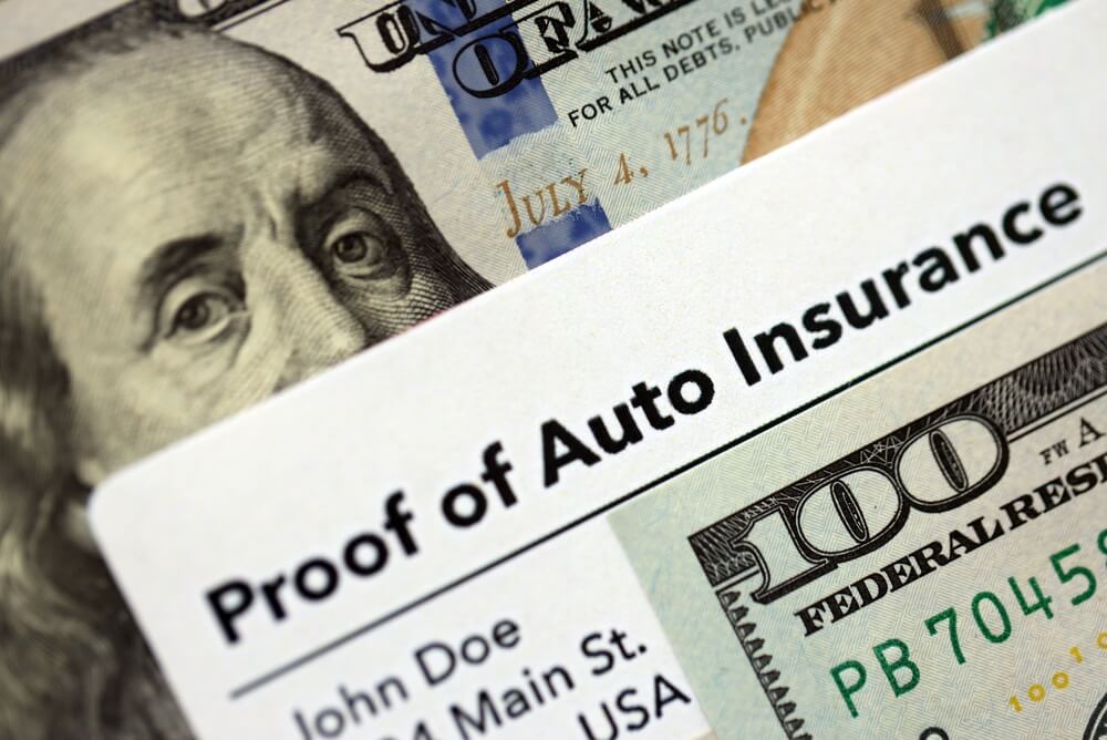 Proof of auto insurance card placed over a $100 bill, highlighting Texas Takes Worry Out of Producing Proof of Insurance.
