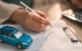 Miniature car on insurance documents