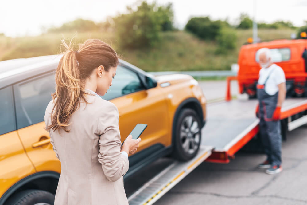Driver arranging roadside assistance after a vehicle breakdown caused by a common roadside issue.