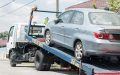 Car loaded onto a tow truck, illustrating potential damage from towing and insurance coverage