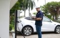 Technician installing an EV charger at home, highlighting home insurance considerations for EV charger installation.
