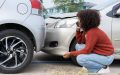 Woman calling after a minor collision, preparing to file a small auto insurance claim.