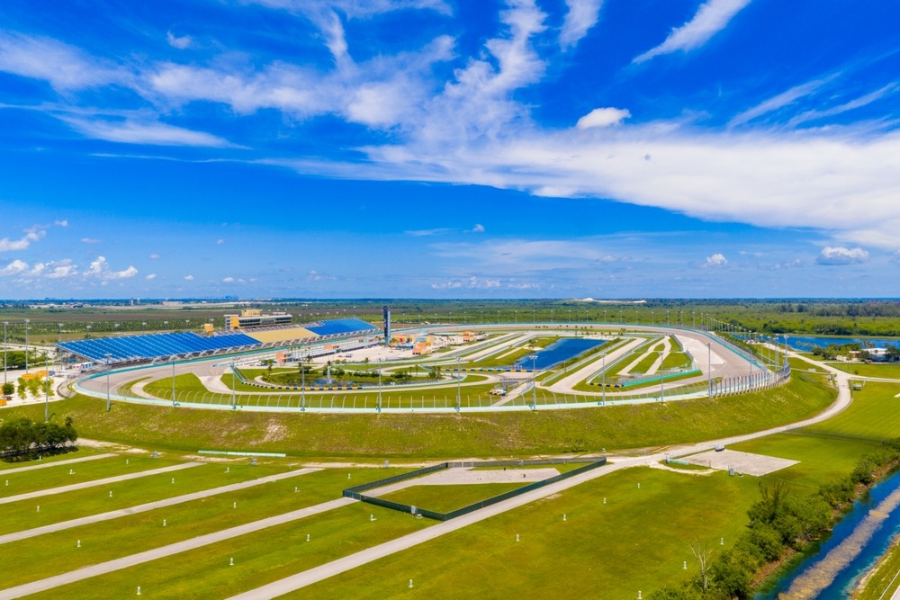Homestead-Miami Speedway racetrack surrounded by green grounds beneath a bright blue sky