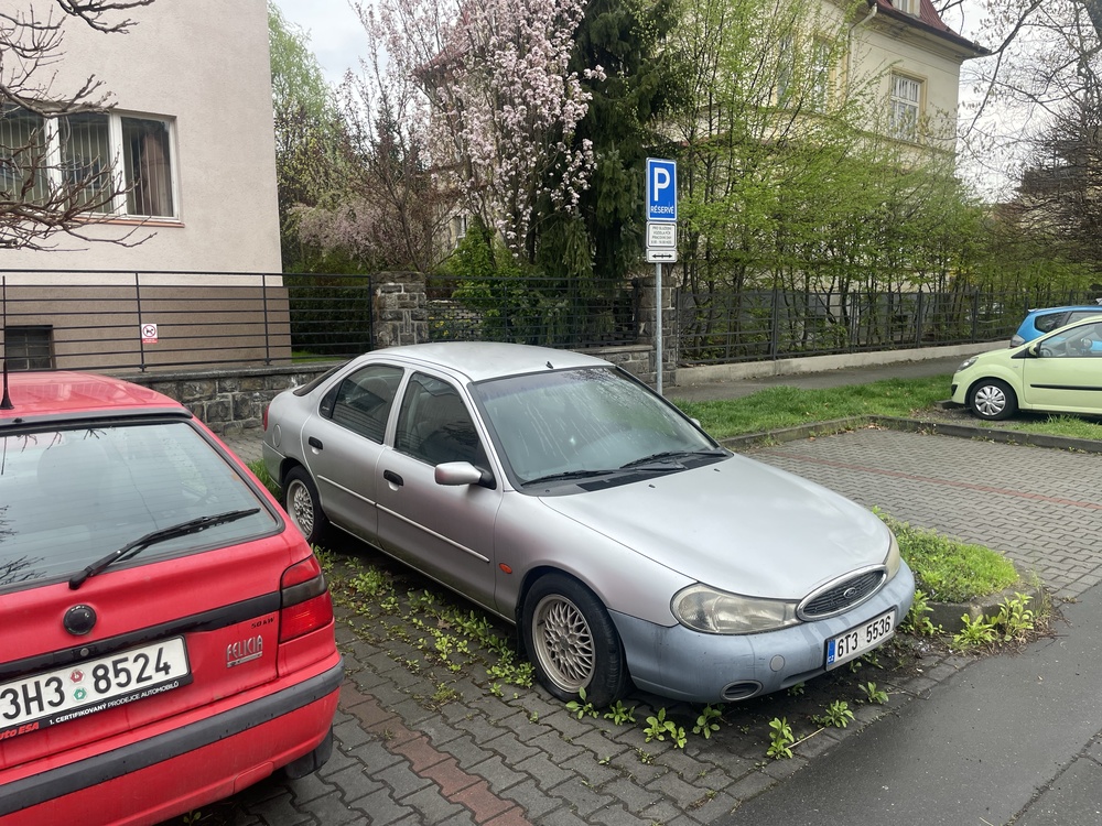 Older cars parked along a residential street.