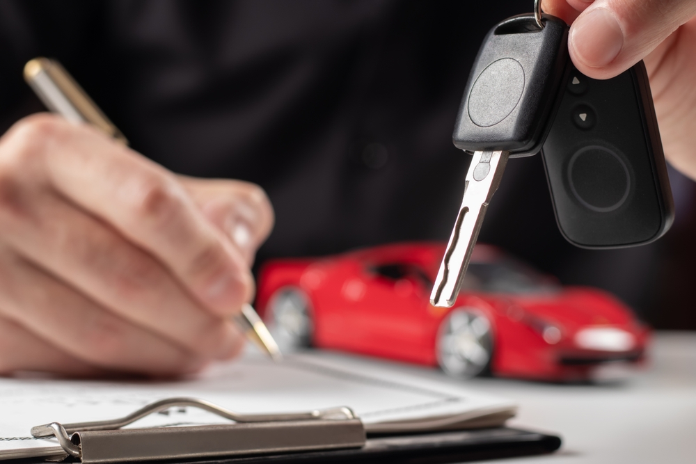 Car keys and paperwork representing the process of shopping for affordable car insurance.