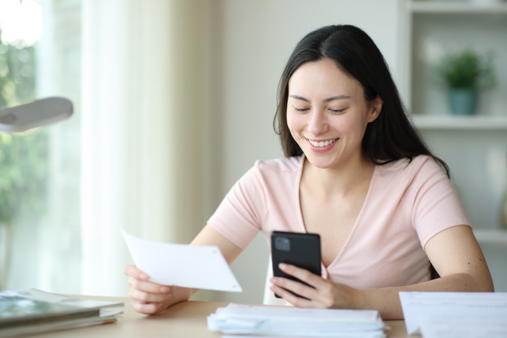 Woman reviewing documents on her phone while learning how to evaluate a renters insurance company.