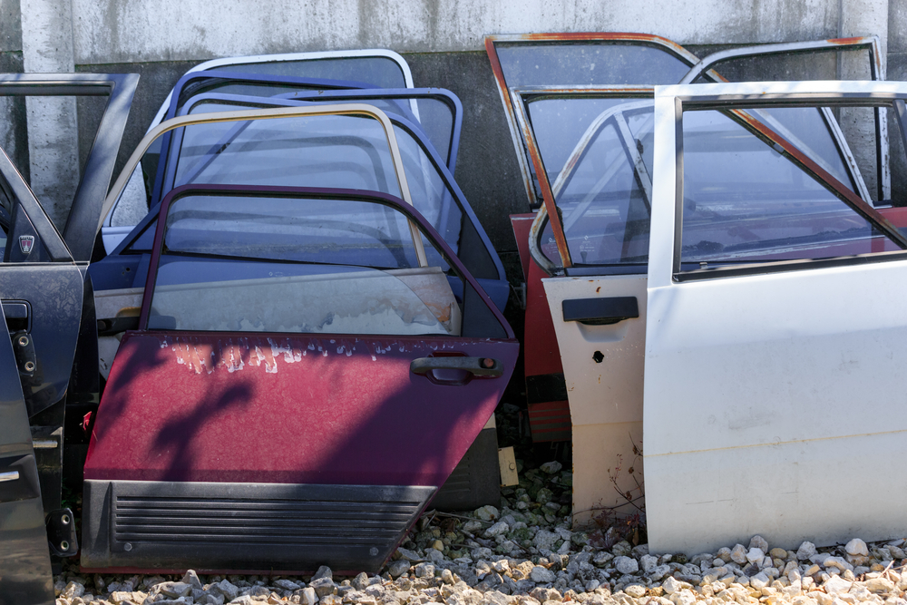 Used aftermarket car parts and replacement doors at an auto salvage yard.