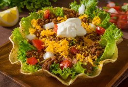 beef taco salad topped with chedder and sour cream