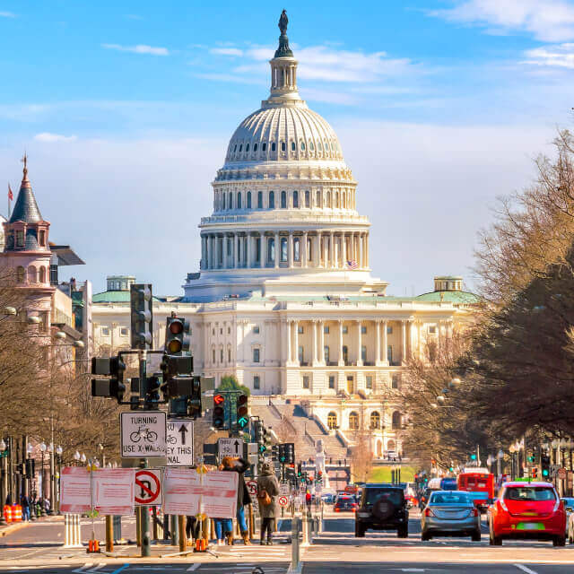 Photo of the US Capitol in Washington DC as seen from a road.