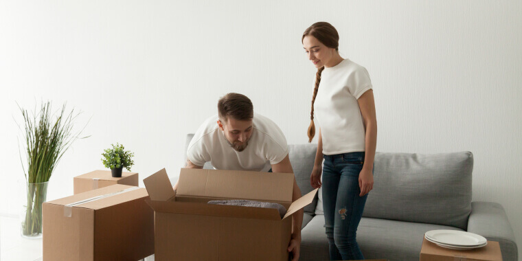 Couple in rented apartment moving boxes