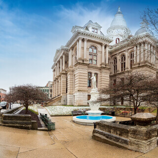 A fountain, trees and a historical building in Lafayette city