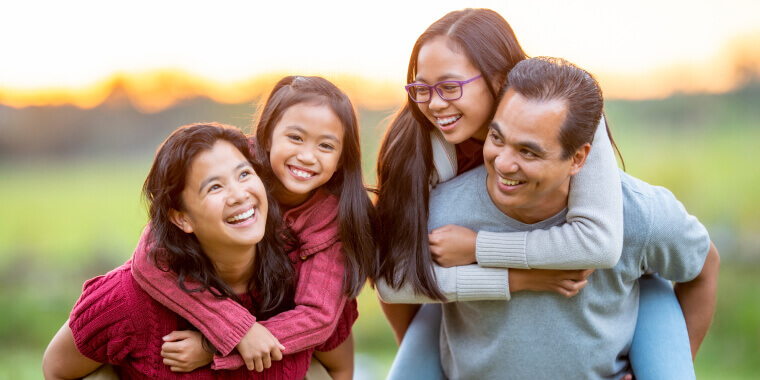 Happy family smiling and playing at the park