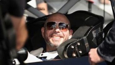 Candid shot of trackhouse racing co-owner and singer Pitbull smiling while sitting in racing car