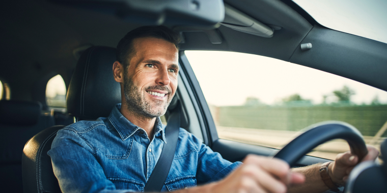 Middle age man inside car driving