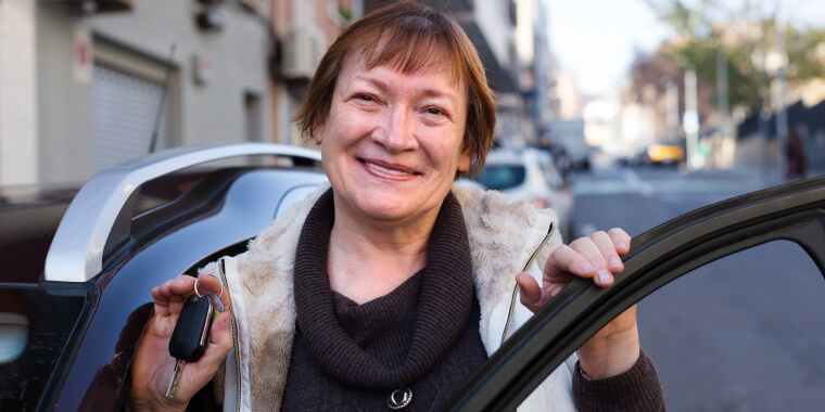 Female driver standing with car key outdoors