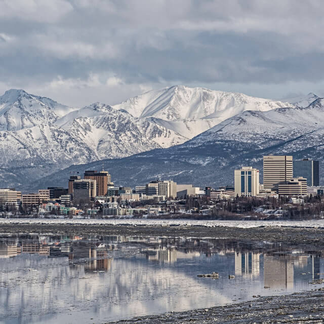 Reflection of Anchorage in the water with mountains in background