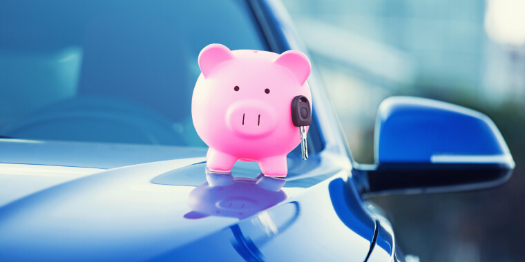 Piggy bank with car keys on top of car safe