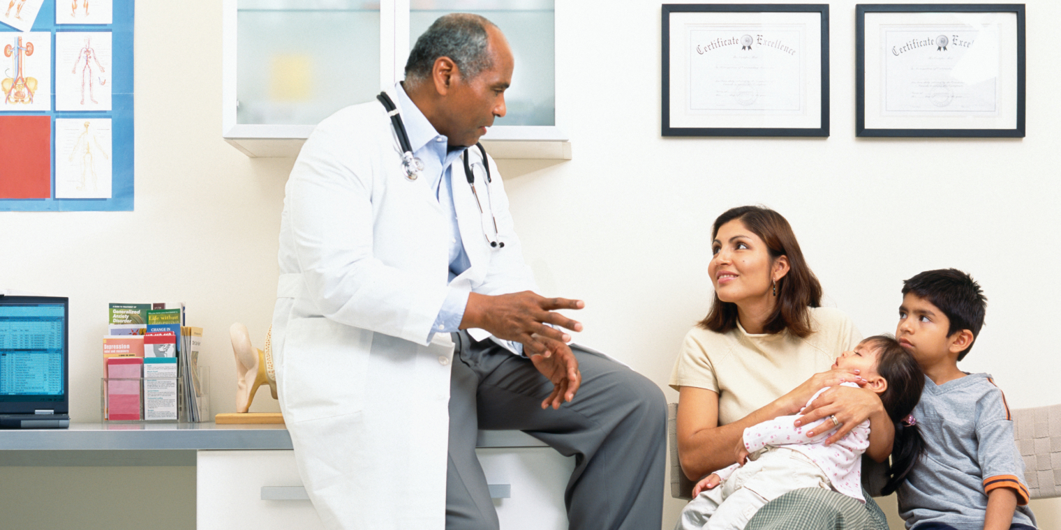 Hispanic mother with daughter and son listening to the instructions of a doctor in his office