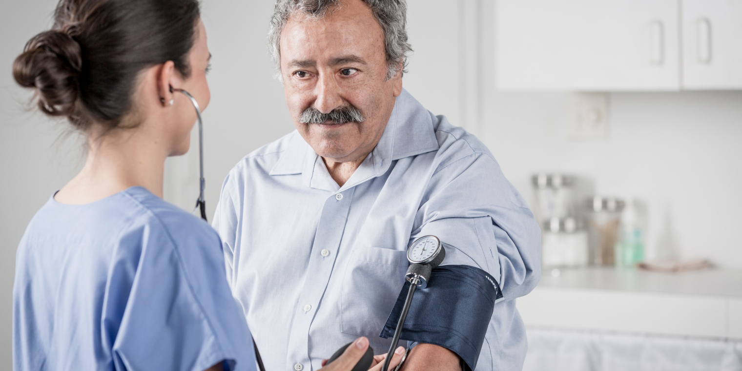 Nurse measuring blood pressure of man