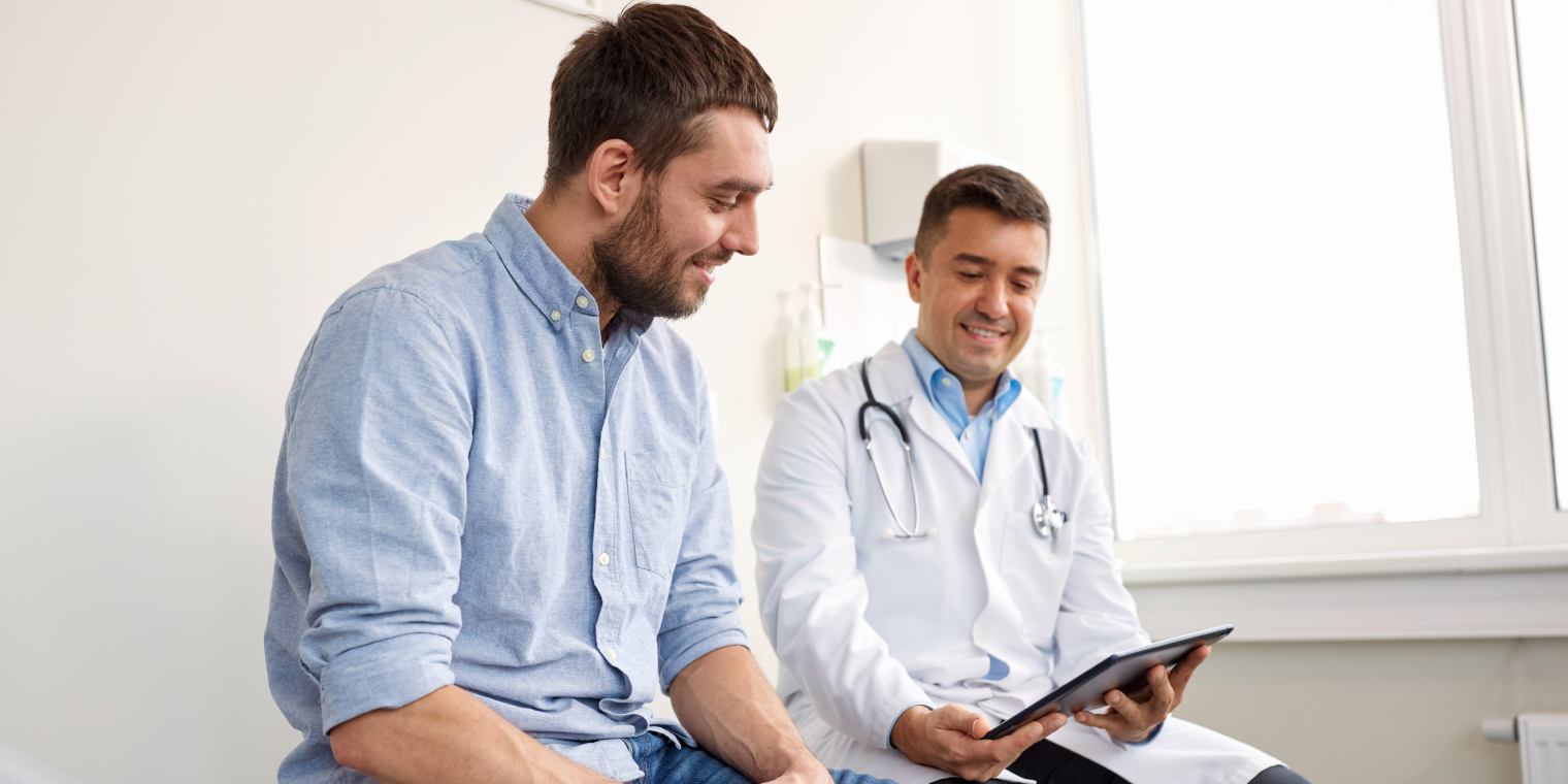 Doctor explaining diagnosis to male patient in tablet