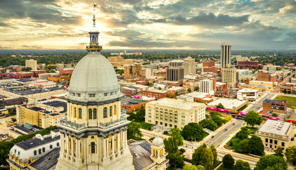 Aerial view of the Illinois State Capitol and the Springfield skyline at sunset.