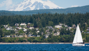 Mount Baker with a sailboat and houses in the Bellingham area