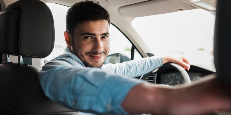  Smiling man behind the wheel of a car