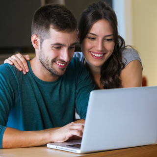 Couple looking at their laptop while making a payment