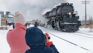 A family photographs the only operating Big Boy steam locomotive engine as it rolls through Greeley on a snowy day.