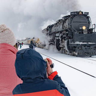 A family photographs the only operating Big Boy steam locomotive engine as it rolls through Greeley on a snowy day.