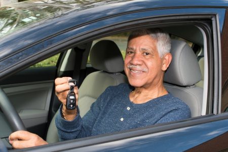 Smiling Hispanic man holds up car keys
