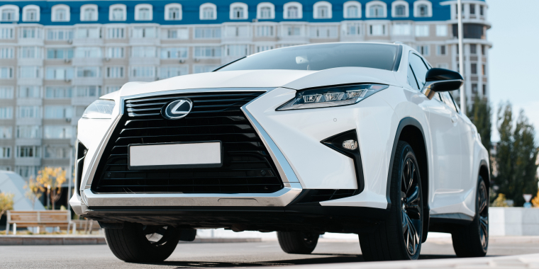2022 White Lexus outdoors. Front view premium crossover car parked on the street, close-up
