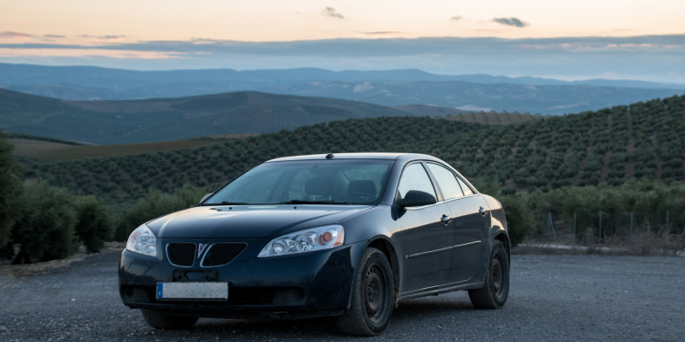 A 2008 Pontiac G6 parked in a Spanish olive tree field.