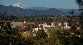 Afternoon snow covered view of the peak of Mount Shasta and the downtown skyline of Redding, California, USA.