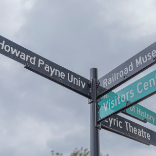 Street Sign with Directions to the Lyric Theatre, Museum of History, Railroad Museum, and Howard Payne University: Brownwood cheap car insurance in Texas.