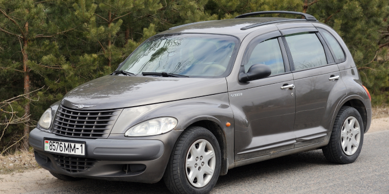 Chrysler PT Cruiser car parked on the road in the forest.
