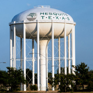 Large white water tower with tree logo print in northeast, Texas: Cheap car insurance in Mesquite, Texas.