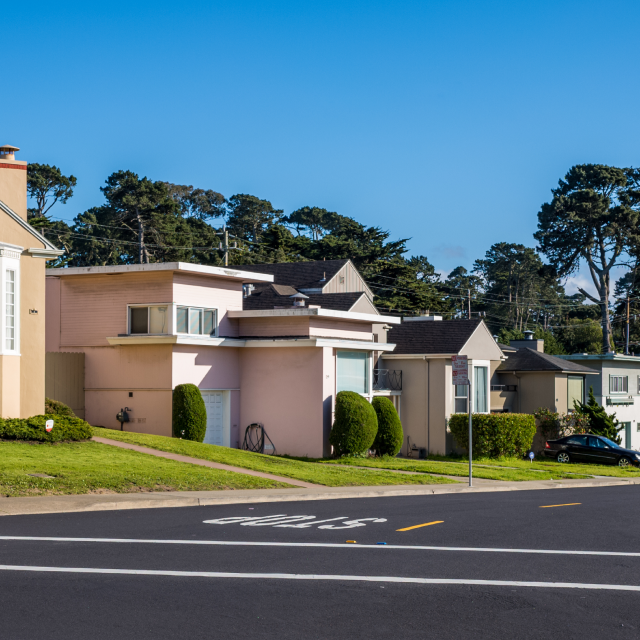 A row of colorful houses lines the street in suburban Daly City, California: Cheap car insurance in The Golden State.