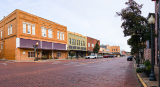 View of downtown Nacogdoches, TX. Brick covered streets and old historic buildings : Cheap car insurance in Texas.