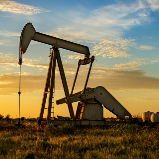 Active oil rig at working at sunrise or sunset: Cheap Car insurance in Odessa, Texas.