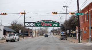 A sign over a road in Mineral Wells, Texas that reads, “Welcome to Mineral Wells - Home of Crazy”: Cheap car insurance in The Lone Star State.