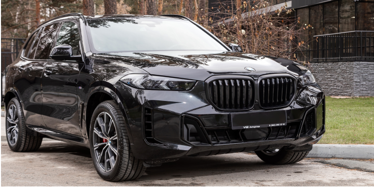Black BMW X5, SUV parked in city , front view.