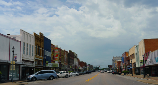 Old buildlings and cars parked on the curb side at the main street of Denison, Texas: Cheap car insurance in Denison, Texas.