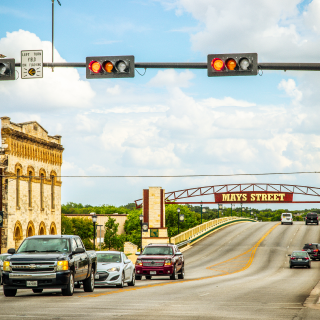 Downtown Round Rock, Texas with businesses under a sunny blue sky: Cheap car insurance in Texas.