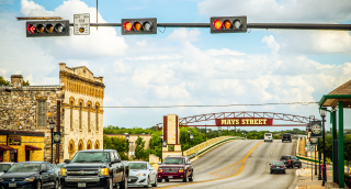 Downtown Round Rock, Texas with businesses under a sunny blue sky: Cheap car insurance in Texas.