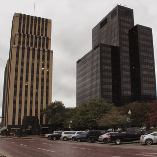 Road and cars parked in Historic Downtown Tyler, TX on cloudy afternoon.