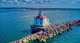 A drone shot of the Ashtabula Harbor Light building under a cloudy sky in Ohio, USA