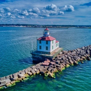 A drone shot of the Ashtabula Harbor Light building under a cloudy sky in Ohio, USA