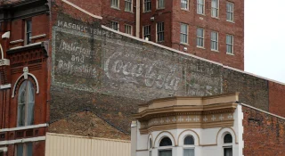 An old, faded, and handpainted Coca-Cola sign is shown on an old, brick, Masonic Temple building – cheap car insurance in Middletown, Ohio.