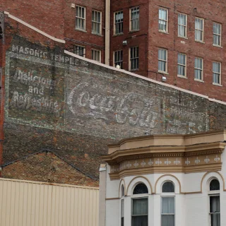 An old, faded, and handpainted Coca-Cola sign is shown on an old, brick, Masonic Temple building – cheap car insurance in Middletown, Ohio.